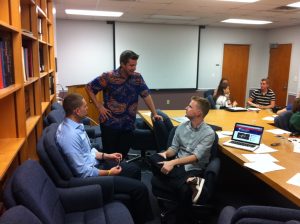 Three men having a discussion in a boardroom