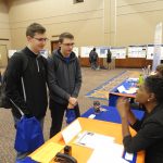 Two students receive information at a career fair booth